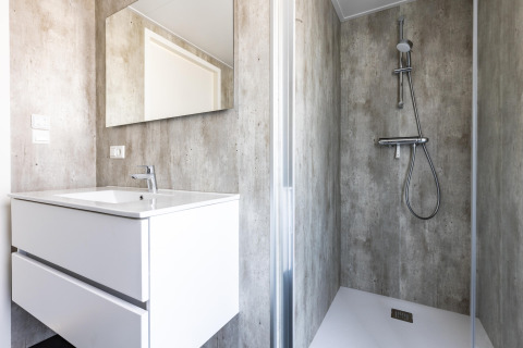 Bagno moderno nello chalet Holiday Park «Molenvelden 7» nei Paesi Bassi con lavabo, specchio e doccia.
