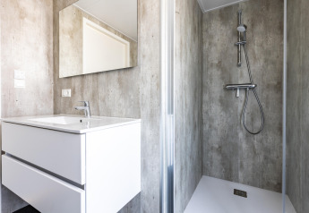 Baño moderno en el chalet Holiday Park «Molenvelden 7» en los Países Bajos con lavabo, espejo y ducha.