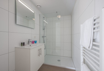 Baño moderno y luminoso con ducha y azulejos blancos en Forest Park 't Wolfsven 9, Países Bajos.