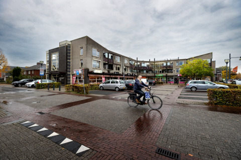 Man cycling through a parking area at Forest Park 't Wolfsven 9 in the Netherlands, cloudy day.