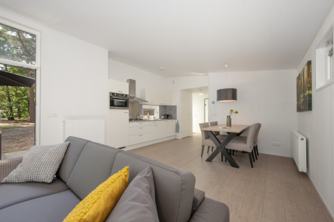 Sala de estar moderna con cocina en Forest Park 't Wolfsven 10, Países Bajos, con mesa y sofá