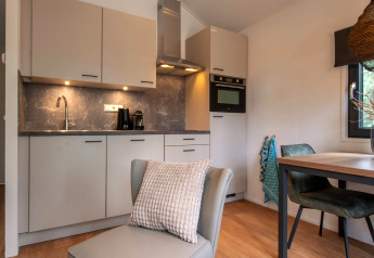 Moderne kitchenette en gezellige eethoek in tiny house Forest Park 't Wolfsven 21 in Nederland.