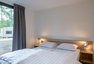 Soveværelse i et lille hus i Forest Park 't Wolfsven 21, Nederlandene, med moderne indretning og udsigt.