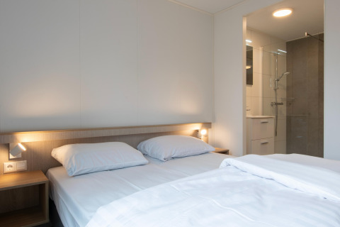 Camera moderna e luminosa con letto matrimoniale e bagno privato al Forest Park 't Wolfsven 21, Paesi Bassi.