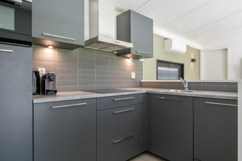 Cocina moderna gris en esquina en Forest Park 't Wolfsven 16, Países Bajos, con armarios elegantes.