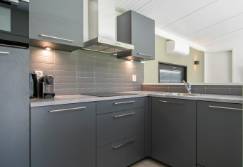 Cocina moderna gris en esquina en Forest Park 't Wolfsven 16, Países Bajos, con armarios elegantes.
