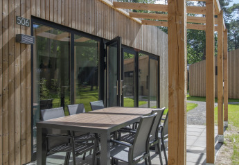 Moderner Holzbungalow mit überdachter Terrasse und Sitzgruppe im Forest Park 't Wolfsven 16, Niederlande.