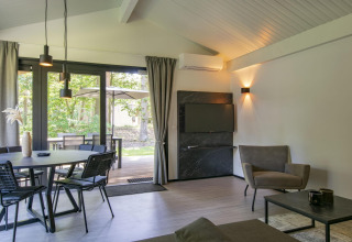 Salón moderno en el chalet Forest Park 't Wolfsven 15 en Países Bajos, comedor y vista al bosque.
