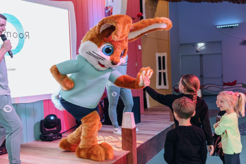 Une grande mascotte de lapin fait un high-five à des enfants au Forest Park 't Wolfsven 15 aux Pays-Bas lors d'un événement.