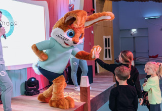 Una grande mascotte di coniglio dà il cinque ai bambini al Forest Park 't Wolfsven 15 nei Paesi Bassi durante un evento.