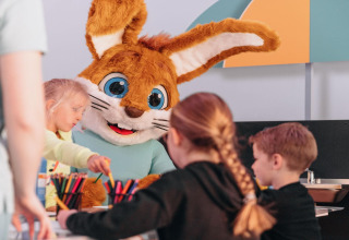 Kinder basteln mit einem riesigen Kaninchenmaskottchen im Forest Park 't Wolfsven 15 in den Niederlanden.