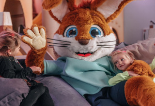 Kinder spielen mit einem als Hase verkleideten Maskottchen im Forest Park 't Wolfsven 15 in den Niederlanden.