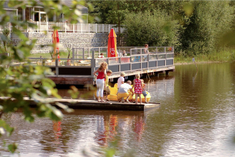 Familie verbringt Freizeit am See bei Forest Park 't Wolfsven 15 mit Terrasse und Tretbooten, Niederlande.