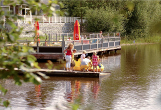 Familie verbringt Freizeit am See bei Forest Park 't Wolfsven 15 mit Terrasse und Tretbooten, Niederlande.