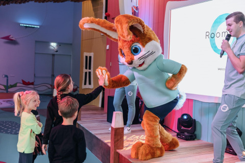 Niños dan un choque de manos a una mascota de conejo en Forest Park 't Wolfsven 13, Países Bajos.