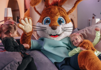 Deux enfants jouent avec une grande mascotte de lapin dans une tente safari au Forest Park 't Wolfsven, Pays-Bas.