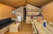 Vue intérieure de la tente safari Forest Park 't Wolfsven 12 aux Pays-Bas, avec mobilier en bois.