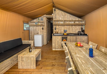 Vue intérieure de la tente safari Forest Park 't Wolfsven 12 aux Pays-Bas, avec mobilier en bois.