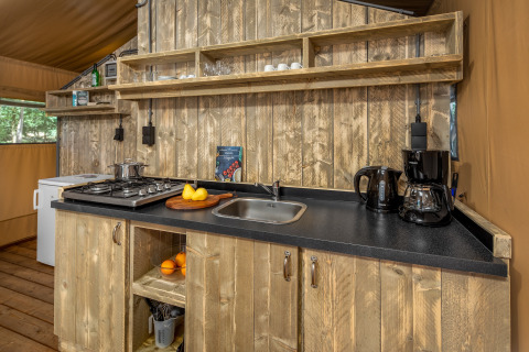 Cuisine d'une tente safari à Forest Park 't Wolfsven 12 aux Pays-Bas avec étagères et plan de travail en bois.