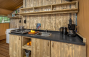 Cuisine d'une tente safari à Forest Park 't Wolfsven 12 aux Pays-Bas avec étagères et plan de travail en bois.