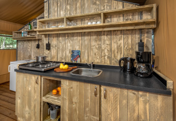 Cuisine d'une tente safari à Forest Park 't Wolfsven 12 aux Pays-Bas avec étagères et plan de travail en bois.