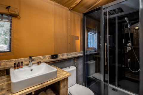 Moderne badeværelse i en safaritelte på Forest Park 't Wolfsven 12, med vask, toilet og brusekabine.