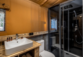 Salle de bains moderne d'une tente safari à Forest Park 't Wolfsven 12, avec lavabo, WC et douche.