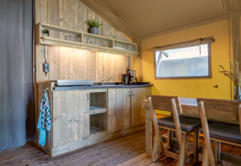 Coin cuisine rustique et coin repas dans la tente safari Holiday Park «Klein Vink 21» aux Pays-Bas.