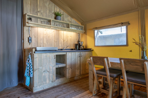 Cucina rustica e area pranzo accogliente nel safari tent Holiday Park «Klein Vink 21» nei Paesi Bassi.