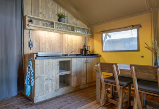 Gemütliche, rustikale Küche und Essbereich im Safarizelt Holiday Park «Klein Vink 21» in den Niederlanden.