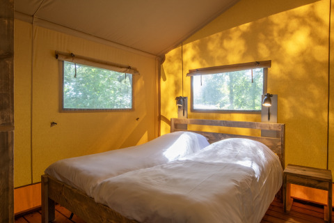Interior view of a safari tent at Holiday Park Klein Vink 21 with twin beds in the Netherlands.