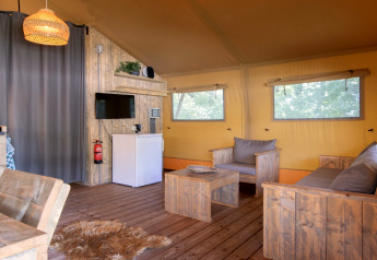 Intérieur d'une tente safari au Holiday Park Klein Vink 21 avec meubles en bois rustiques et décoration chaleureuse.