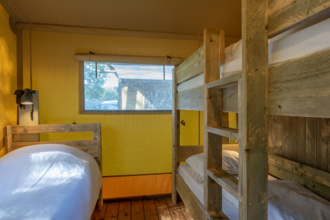 Indvendigt af et safaritelt på Holiday Park «Klein Vink 21» med køjeseng og enkeltseng i Holland.