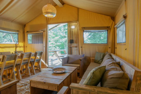 Indvendigt billede af en hyggelig safaritelts stue og spiseområde ved Holiday Park Klein Vink i Holland.