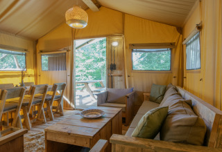Indvendigt billede af en hyggelig safaritelts stue og spiseområde ved Holiday Park Klein Vink i Holland.
