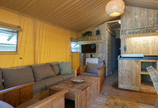 Interno di tenda safari accogliente con arredi in legno al Holiday Park Klein Vink nei Paesi Bassi.