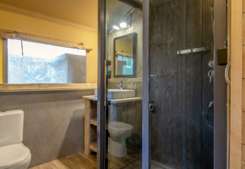 Salle de bain dans une tente safari au Holiday Park « Klein Vink 21 » aux Pays-Bas avec déco bois.