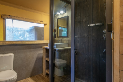 Badeværelse i safari-telt på Holiday Park «Klein Vink 21» med moderne faciliteter og træinteriør.