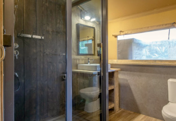 Salle de bain moderne sous tente safari au Holiday Park Klein Vink 21 avec douche, lavabo et toilettes.