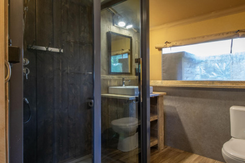 Modern bathroom in a safari tent at Holiday Park Klein Vink 21 with shower, sink, and toilet facilities.
