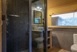 Bagno moderno in una tenda safari al Holiday Park Klein Vink 21 con doccia, lavabo e servizi igienici.