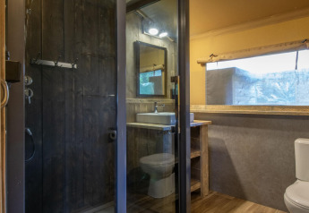 Baño moderno en tienda safari del Holiday Park Klein Vink 21, con ducha, lavabo y sanitario visible.