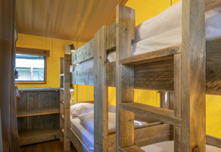 Letti a castello in legno e finestra in una camera accogliente del safari tent Holiday Park Klein Vink 20, Paesi Bassi.