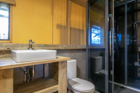 Baño moderno en una tienda safari con lavabo, inodoro y ducha, en el Holiday Park Klein Vink 20 en los Países Bajos.