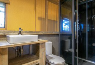 Modern bathroom inside a safari tent at Holiday Park Klein Vink 20 with sink, toilet, and shower in the Netherlands.