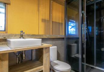 Baño moderno en una tienda safari con lavabo, inodoro y ducha, en el Holiday Park Klein Vink 20 en los Países Bajos.