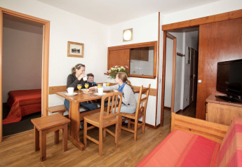 Family enjoys breakfast together at a wooden dining table in a cozy apartment at Holiday Park Klein Vink.