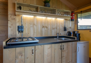 Cocina compacta en tienda safari del Holiday Park Klein Vink 19, Países Bajos, con estufa y fregadero.