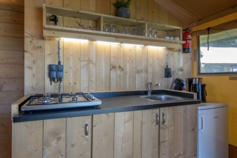 Cocina compacta en tienda safari del Holiday Park Klein Vink 19, Países Bajos, con estufa y fregadero.