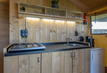 Kompakte Küchenzeile im Safarizelt des Holiday Park Klein Vink 19, Niederlande, mit Herd und Spüle.